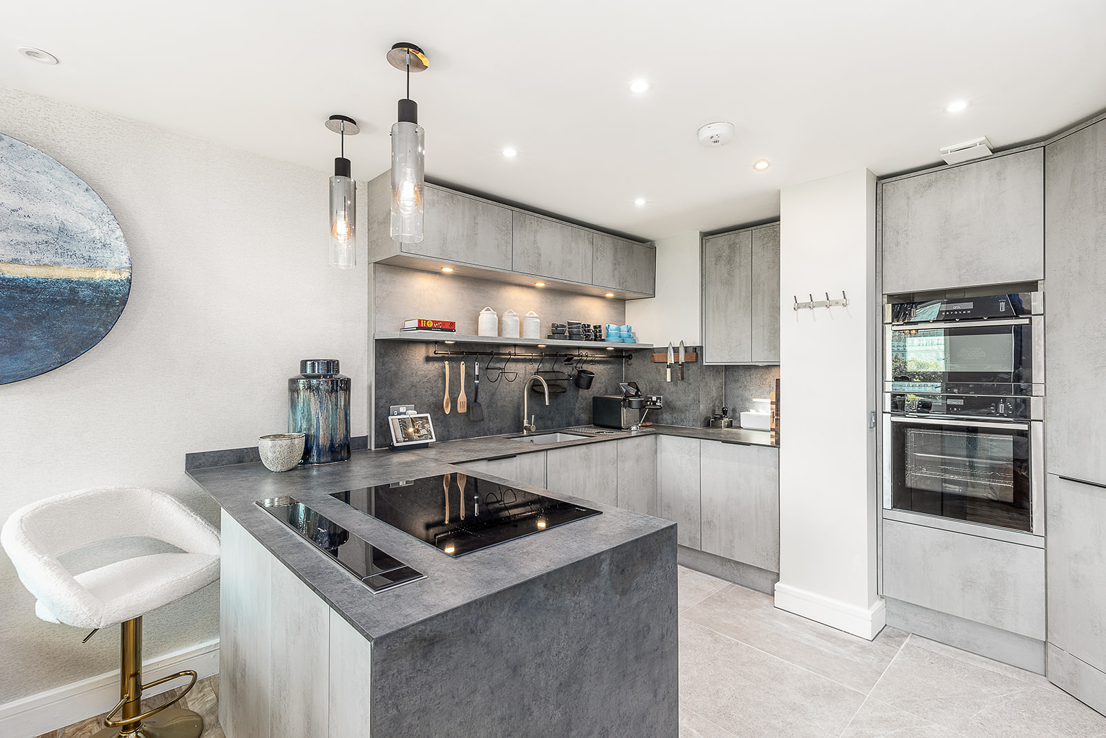 London Embankment Apartment kitchen — concrete-effect cabinetry, induction hob, pendant lighting